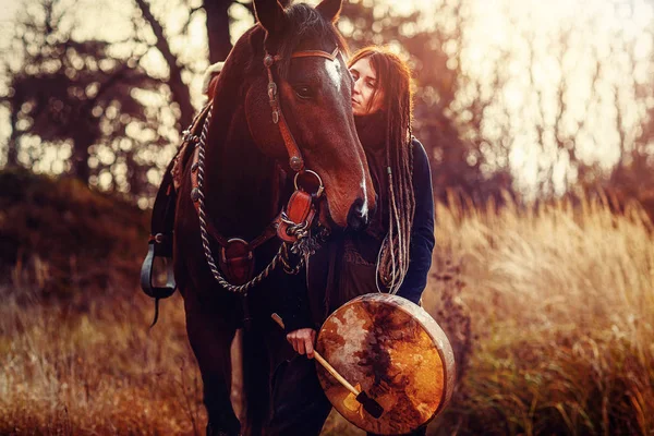 Νεαρή φοβισμένη κοπέλα με το άλογό της και σαμανικό τύμπανο πλαίσιο. — Φωτογραφία Αρχείου