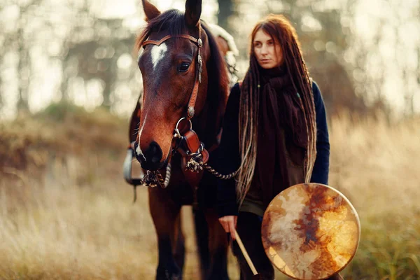 Νεαρή φοβισμένη κοπέλα με το άλογό της και σαμανικό τύμπανο πλαίσιο. — Φωτογραφία Αρχείου