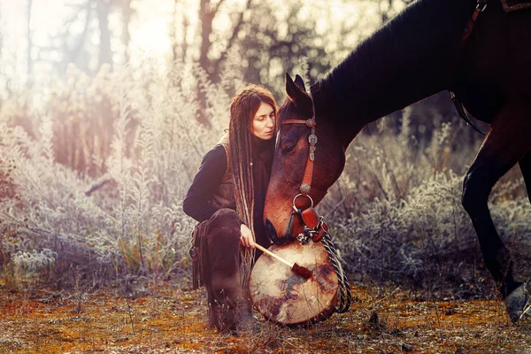 Молода сновидіння дівчина зі своїм конем і шаманським барабаном . — стокове фото