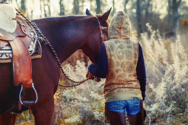 Ung vacker fruktad flicka utomhus med sin häst. — Stockfoto