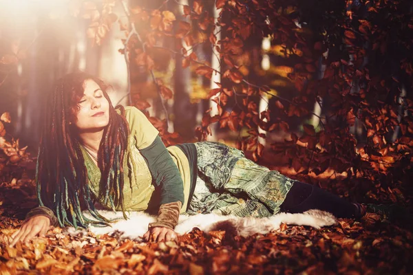 Beautiful woman with long dreadlocks in nature. — Stock Photo, Image