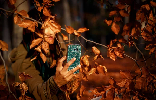 Дівчина в лісі з мобільним телефоном в руках . — стокове фото