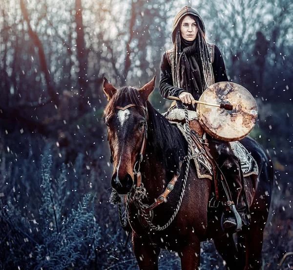 Young dreadded girl with her horse and shamanic frame drum. — Stock Photo, Image
