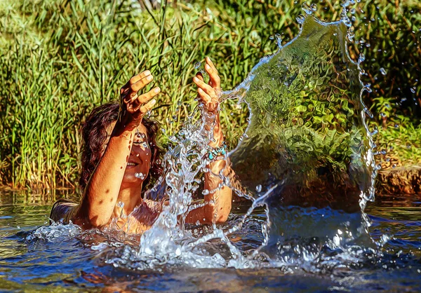 Красивая женщина в озере плещет водой и эффектом живописи . — стоковое фото