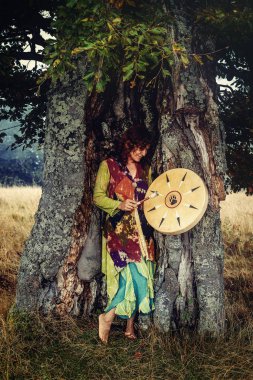 Şaman çerçeveli davul çalan güzel bir şaman kız.
