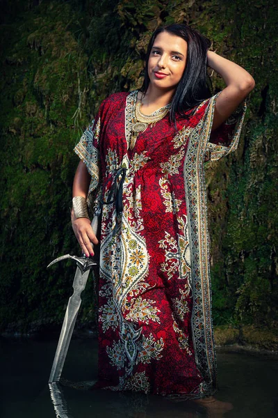 Жінка з мечем в озері біля водоспаду . — стокове фото
