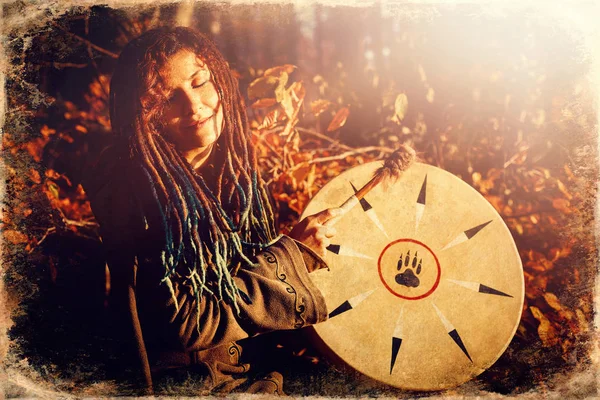 Bela garota xamânica jogando no tambor quadro xamã na natureza, efeito de foto velha . — Fotografia de Stock