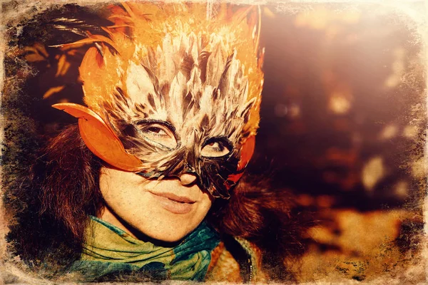 Mladá žena s barevnou péřovou obličejovou maskou, starý fotografický efekt. — Stock fotografie