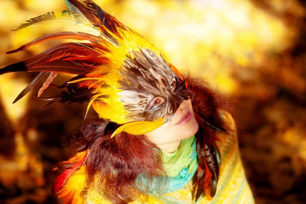 Mujer joven con una máscara de plumas de colores . —  Fotos de Stock