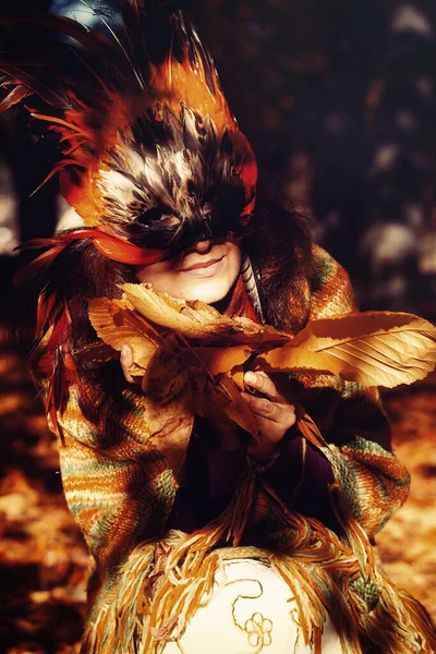 Jonge vrouw met een kleurrijk vedermasker. — Stockfoto