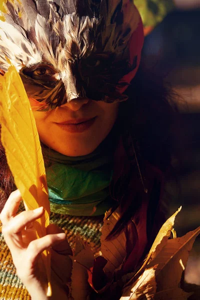 Young woman with a colorful feather face mask. — Stock Photo, Image