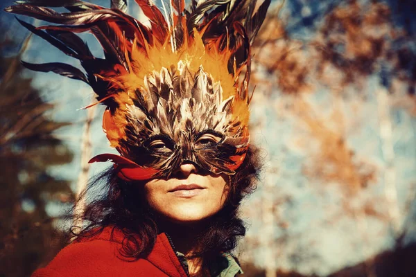 Young woman with a colorful feather face mask. — Stock Photo, Image