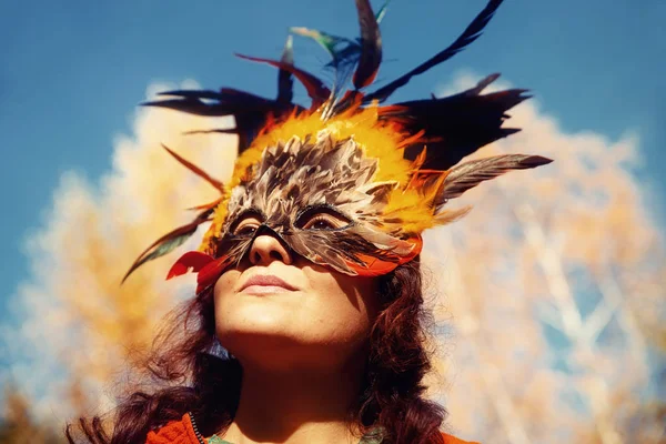 Jonge vrouw met een kleurrijk vedermasker. — Stockfoto