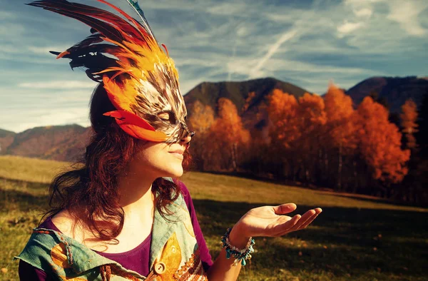 Jonge vrouw met een kleurrijk vedermasker. — Stockfoto