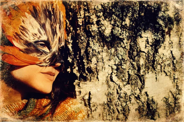 Young woman with a colorful feather face mask, old photo effect. — Stock Photo, Image