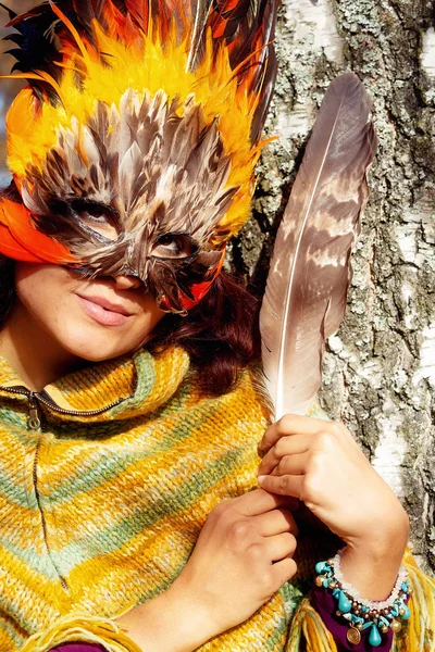 Jonge vrouw met een kleurrijk vedermasker. — Stockfoto