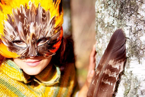 Junge Frau mit bunter Federgesichtsmaske. — Stockfoto