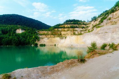 Güzel manzara, taş ocağında göl ve arka planda dağ.