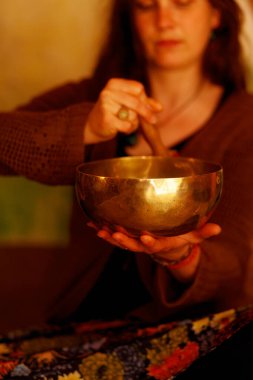 Tibet kâsesinin meditasyon seslerine dalmış ruhani kız.