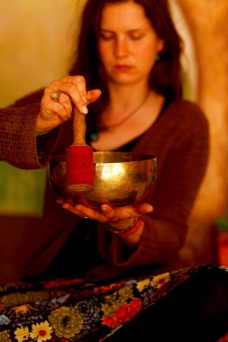 Tibet kâsesinin meditasyon seslerine dalmış ruhani kız.