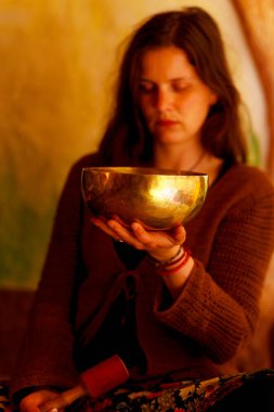 Tibet kâsesinin meditasyon seslerine dalmış ruhani kız.