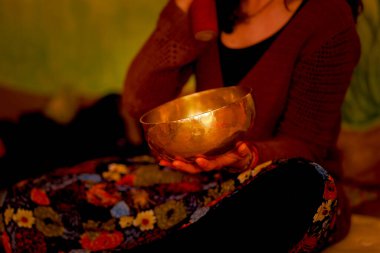 Tibet kâsesinin meditasyon seslerine dalmış ruhani kız.