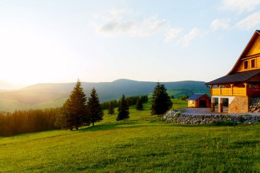 Dağlardaki kır evi ve yeşil çayır. Gün batımı manzarası. Slovakya