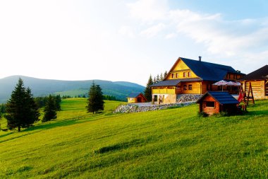 Dağlardaki kır evi ve yeşil çayır. Gün batımı manzarası. Slovakya