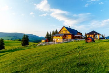 Dağlardaki kır evi ve yeşil çayır. Gün batımı manzarası. Slovakya