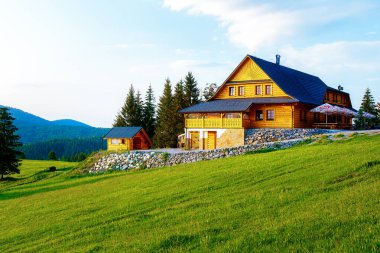 Dağlardaki kır evi ve yeşil çayır. Gün batımı manzarası. Slovakya