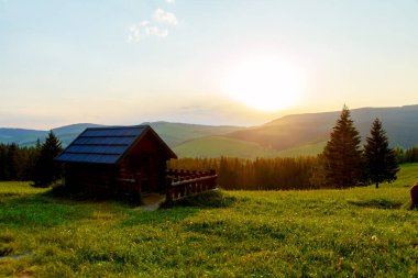 Dağlardaki kır evi ve yeşil çayır. Gün batımı manzarası. Slovakya