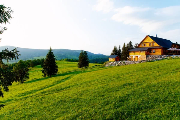 Dağlardaki kır evi ve yeşil çayır. Gün batımı manzarası. Slovakya