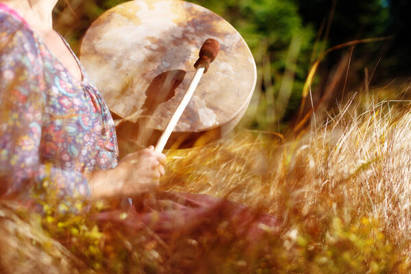 Shaman frame drum in woman hand in the nature
