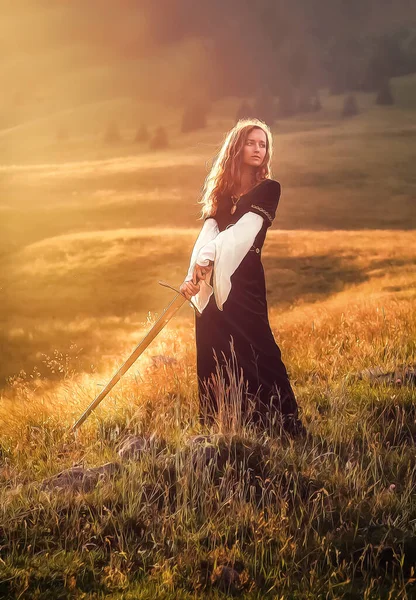 Belle femme avec épée dans un vêtement historique, effet peinture . — Photo
