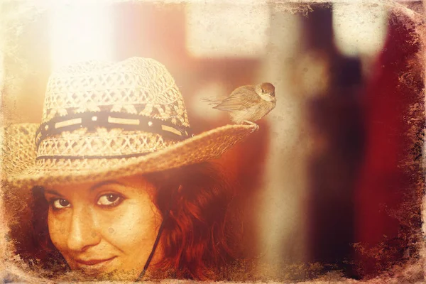 Mulher com um pequeno pássaro. pássaro em um chapéu, velho efeito de foto . — Fotografia de Stock