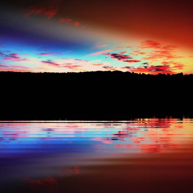 Suya yansıyan dramatik gökyüzü ile karanlık manzara