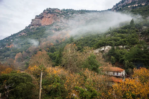 Foggy autumn landscape with houses and mountains  in Vouraikos g — Stock Photo, Image