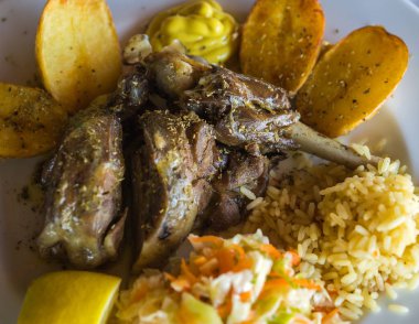 Kızarmış kuzu bacak patates, pirinç ve sebze salatası ile