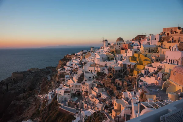 White city on  slope of  hill at sunset, Oia, Santorini