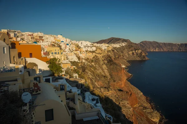 White city on  slope of  hill at sunset, Oia, Santorini