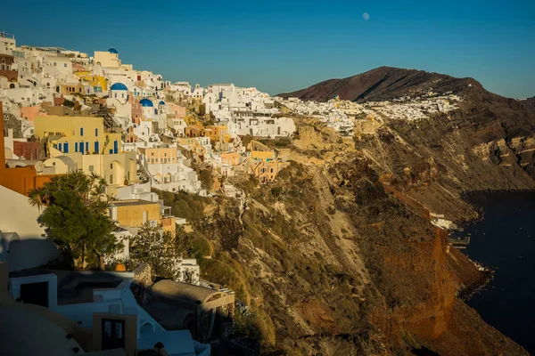 Ville blanche sur la pente de la colline au coucher du soleil, Oia, Santorin — Photo