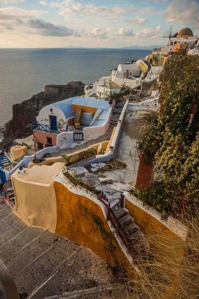 White city on a slope of a hill at sunset, Oia, Santorini, Greec