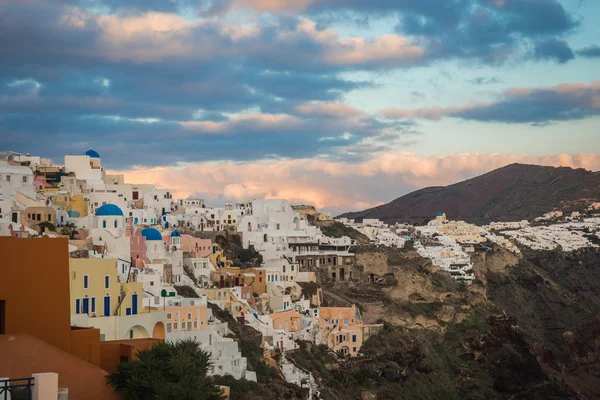 Ville blanche sur une pente d'une colline au coucher du soleil, Oia, Santorin, Greec — Photo