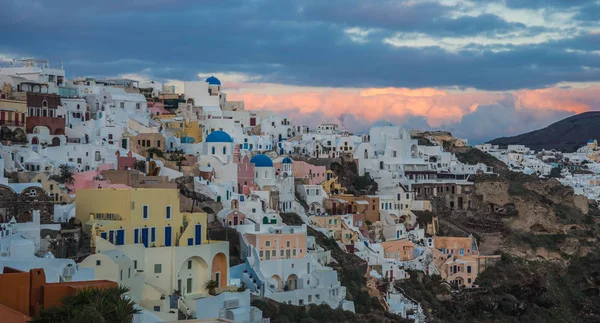 Ville blanche sur une pente d'une colline au coucher du soleil, Oia, Santorin, Greec — Photo