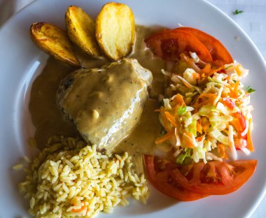 Kızarmış biftek rokfor soslu patates, pilav ve salata ile 