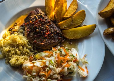 Kızarmış biftek biber soslu patates, pilav ve salata ile