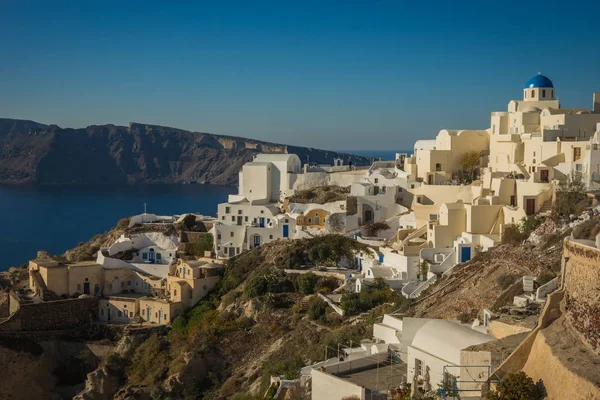 White city on a slope of a hill at sunset, Oia, Santorini, Greec — Stock Photo, Image