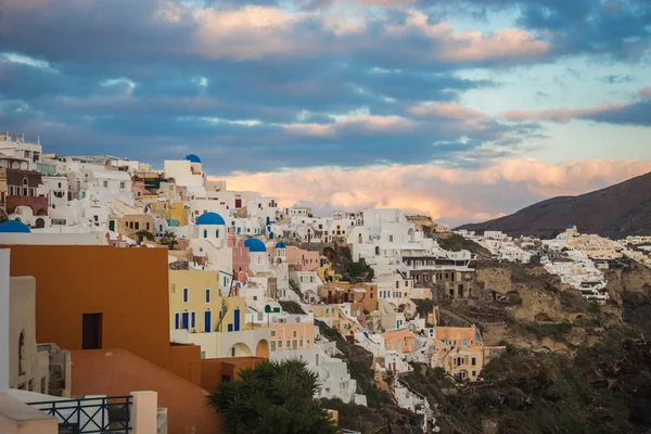 Ville blanche sur une pente d'une colline au coucher du soleil, Oia, Santorin, Greec — Photo