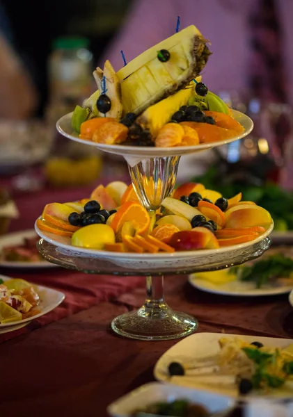 Pratos com frutas frescas fatiadas em uma mesa festiva — Fotografia de Stock
