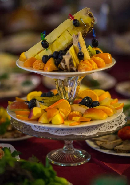 Pratos com frutas frescas fatiadas em uma mesa festiva — Fotografia de Stock